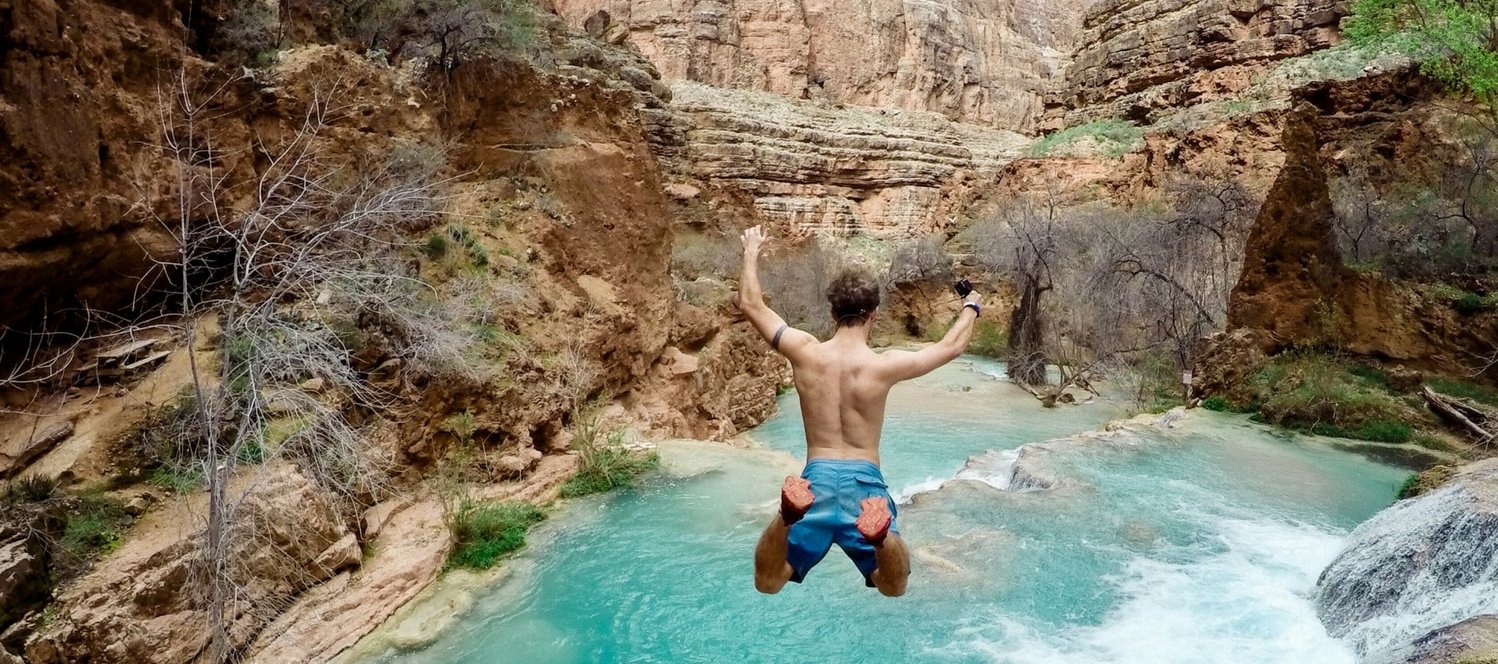Gap year student jumping into a waterfall in Costa Rica